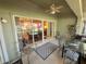 Covered patio features a ceiling fan, rug, and outdoor seating, accessible through sliding glass doors at 18142 Baywood Forest Dr, Hudson, FL 34667