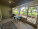 View of a screened patio with a glass table and an outdoor seating area surrounded by a beautiful landscape at 18142 Baywood Forest Dr, Hudson, FL 34667