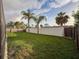 Large backyard featuring privacy fencing, lush green lawn, and mature palm trees creating a private outdoor space at 10029 Freestone Ln, Port Richey, FL 34668
