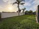 Spacious backyard featuring lush green grass, mature trees, and privacy fencing for a serene outdoor space at 10029 Freestone Ln, Port Richey, FL 34668
