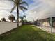 Beautiful backyard view featuring a pool in a screened enclosure, palm trees, and well-maintained fencing at 10029 Freestone Ln, Port Richey, FL 34668
