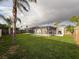Expansive backyard with a pristine pool, enclosed patio dining, and a well-kept lawn for outdoor enjoyment at 10029 Freestone Ln, Port Richey, FL 34668