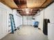 Unfinished basement with ladder, exposed beams, and some personal items at 10029 Freestone Ln, Port Richey, FL 34668