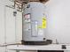Basement showing water heater and its plumbing, along with adjacent shelving at 10029 Freestone Ln, Port Richey, FL 34668
