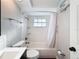 Cozy bathroom featuring a tub/shower with white tile, toilet and dark vanity at 10029 Freestone Ln, Port Richey, FL 34668