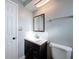 Bright bathroom featuring a toilet, and dark vanity with a framed mirror at 10029 Freestone Ln, Port Richey, FL 34668