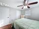 Well-lit bedroom featuring a ceiling fan, closet, and hardwood floors at 10029 Freestone Ln, Port Richey, FL 34668
