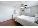 Bedroom features ceiling fan, dresser with mirror, window for natural light, and wood-look floors at 10029 Freestone Ln, Port Richey, FL 34668