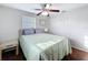 Bedroom with hardwood floors, windows with blinds, ceiling fan and side tables at 10029 Freestone Ln, Port Richey, FL 34668