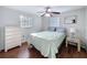 Bedroom with hardwood floors, large windows, ceiling fan and light-colored dresser at 10029 Freestone Ln, Port Richey, FL 34668