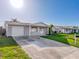 Exterior view of a single-story home featuring an attached garage, complemented by manicured lawns and shrubs at 10029 Freestone Ln, Port Richey, FL 34668