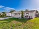Well-maintained home with an attached garage, complemented by a green lawn and colorful landscaping at 10029 Freestone Ln, Port Richey, FL 34668