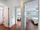 Hallway with multiple bedrooms and a bathroom, featuring doors and wood-look flooring throughout at 10029 Freestone Ln, Port Richey, FL 34668