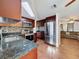 Open-concept kitchen featuring stainless steel appliances, tile backsplash, and granite countertops at 10029 Freestone Ln, Port Richey, FL 34668