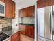 Kitchen features stainless steel appliances, wood cabinets, granite countertops, and tile backsplash at 10029 Freestone Ln, Port Richey, FL 34668