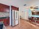 Kitchen dining area with stainless steel refrigerator, tile backsplash and wood-look floors at 10029 Freestone Ln, Port Richey, FL 34668