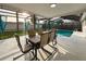 Screened-in patio with dining table and chairs overlooking a pool at 10029 Freestone Ln, Port Richey, FL 34668