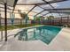 Sparkling pool area surrounded by a screened enclosure and lush landscaping at 10029 Freestone Ln, Port Richey, FL 34668
