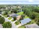 Beautiful aerial view of the property with a tranquil pond, mature trees, and manicured lawns at 10097 Holly Berry Dr, Weeki Wachee, FL 34613