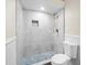 Modern bathroom with sleek gray tile shower, rain shower head, and mosaic tile floor at 10097 Holly Berry Dr, Weeki Wachee, FL 34613