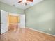 Open bedroom with ceiling fan and hardwood floors leads to additional living space at 10097 Holly Berry Dr, Weeki Wachee, FL 34613