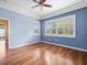 Bright bedroom with wood floors, blue walls, trey ceiling, ceiling fan, and two large windows at 10097 Holly Berry Dr, Weeki Wachee, FL 34613