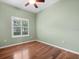 Cozy bedroom with wood floors, green walls, and a large window at 10097 Holly Berry Dr, Weeki Wachee, FL 34613