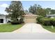 Well-maintained home features a two-car garage and mature landscaping at 10097 Holly Berry Dr, Weeki Wachee, FL 34613