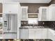 Bright kitchen with white cabinets, granite countertops, stainless steel appliances, and tile flooring at 10097 Holly Berry Dr, Weeki Wachee, FL 34613