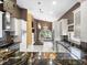 Elegant kitchen with black granite counters, center island, stainless appliances and contrasting white cabinets at 10097 Holly Berry Dr, Weeki Wachee, FL 34613