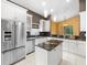Bright kitchen with white cabinets, stainless steel appliances, granite counters, and central island at 10097 Holly Berry Dr, Weeki Wachee, FL 34613