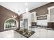 Well lit kitchen features an island, stainless appliances, granite counters, and a large arched window at 10097 Holly Berry Dr, Weeki Wachee, FL 34613