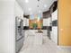 Spacious kitchen with white cabinets, stainless steel appliances, an island, and tile flooring throughout at 10097 Holly Berry Dr, Weeki Wachee, FL 34613