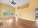 Bright living room with wood floors, yellow walls, vaulted ceilings, and large window at 10097 Holly Berry Dr, Weeki Wachee, FL 34613