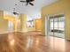 Spacious living room with wood floors, yellow walls, vaulted ceilings, and access to outdoor space at 10097 Holly Berry Dr, Weeki Wachee, FL 34613