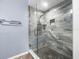 Modern walk-in shower with pebble floor and light blue stone-look tile at 10097 Holly Berry Dr, Weeki Wachee, FL 34613