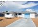Charming home with a white exterior, blue shutters, a light blue garage door, and low maintenance landscaping at 10123 Oak Hill Dr, Port Richey, FL 34668