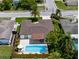 An aerial view of a home shows the backyard pool, patio and mature landscaping surrounding the property at 10224 Old Orchard Ln, Port Richey, FL 34668