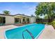 Beautiful backyard featuring a sparkling pool, covered patio, and well-maintained landscaping, ideal for outdoor entertaining at 10224 Old Orchard Ln, Port Richey, FL 34668
