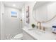 Modern bathroom features a white vanity, granite countertops, a mosaic tile floor, and a round mirror at 10224 Old Orchard Ln, Port Richey, FL 34668