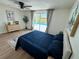 A bright bedroom offers a ceiling fan and sliding glass doors that lead to a large, screened-in private pool at 10224 Old Orchard Ln, Port Richey, FL 34668