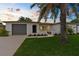 Charming single-story home with a well-manicured lawn, tidy landscaping, and attached garage at 10224 Old Orchard Ln, Port Richey, FL 34668