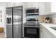 Contemporary kitchen featuring stainless steel appliances, bright white cabinetry, and modern backsplash at 10224 Old Orchard Ln, Port Richey, FL 34668