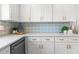 Beautiful kitchen detail featuring white cabinets, quartz countertops, and unique backsplash at 10224 Old Orchard Ln, Port Richey, FL 34668