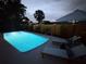 A backyard offers an inviting rectangular swimming pool and comfortable lounge chairs for outdoor relaxation at 10224 Old Orchard Ln, Port Richey, FL 34668