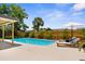 Lush backyard featuring a pool, lounge chairs, and a covered patio, blending relaxation and entertainment seamlessly at 10224 Old Orchard Ln, Port Richey, FL 34668