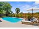 Sparkling swimming pool surrounded by lush landscaping, creating a serene backyard oasis with lounge chairs at 10224 Old Orchard Ln, Port Richey, FL 34668