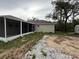 Back exterior view showcases a screen patio and the home's neutral color palette at 11308 Mahopac Rd, Weeki Wachee, FL 34614