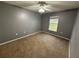 Comfortable bedroom with neutral walls, a ceiling fan, and a window that brightens the space at 11308 Mahopac Rd, Weeki Wachee, FL 34614
