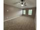 Cozy bedroom with plush carpeting, a ceiling fan, and natural light streaming through two windows at 11308 Mahopac Rd, Weeki Wachee, FL 34614